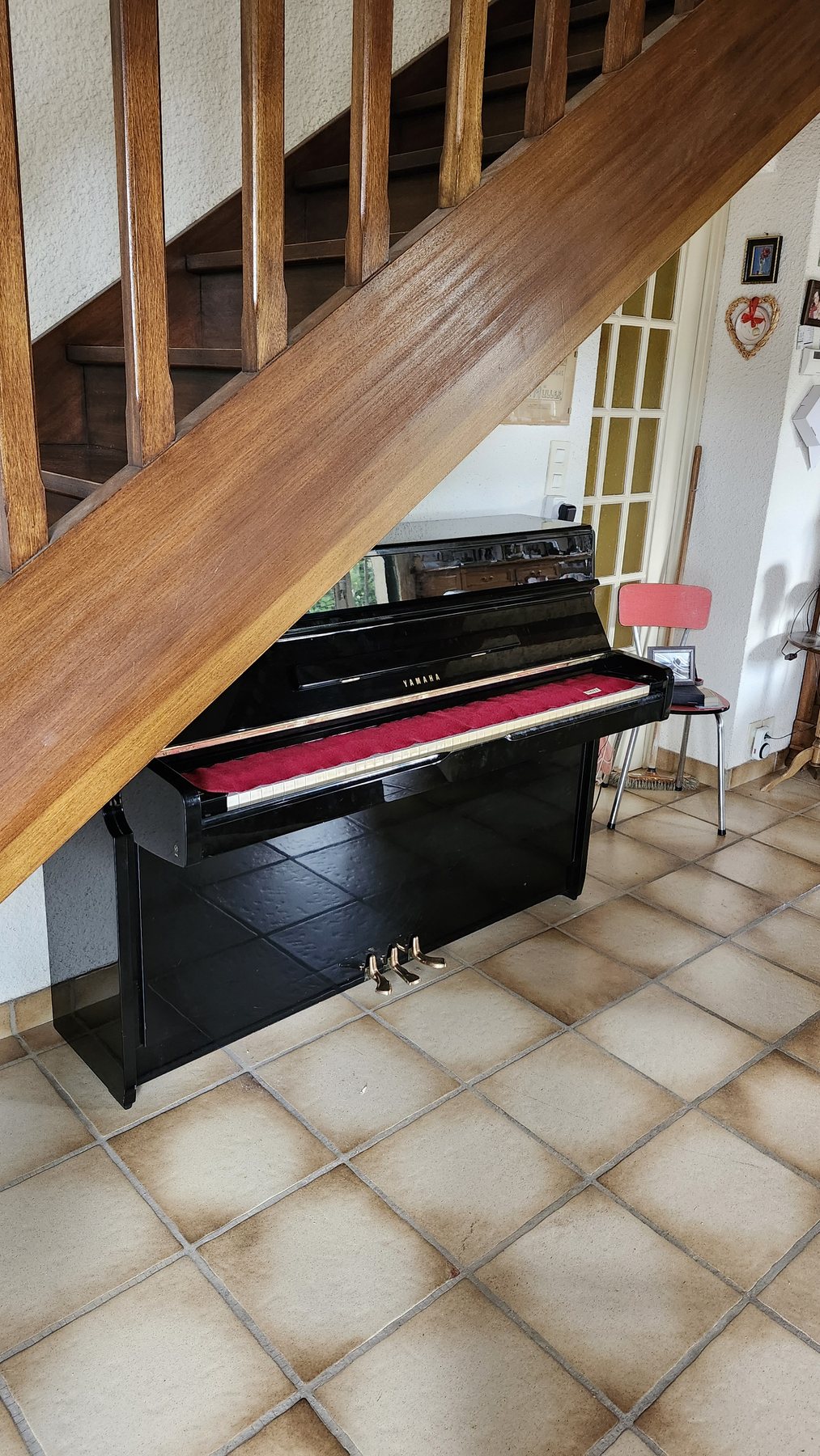 Piano droit installé sous un escalier après transport