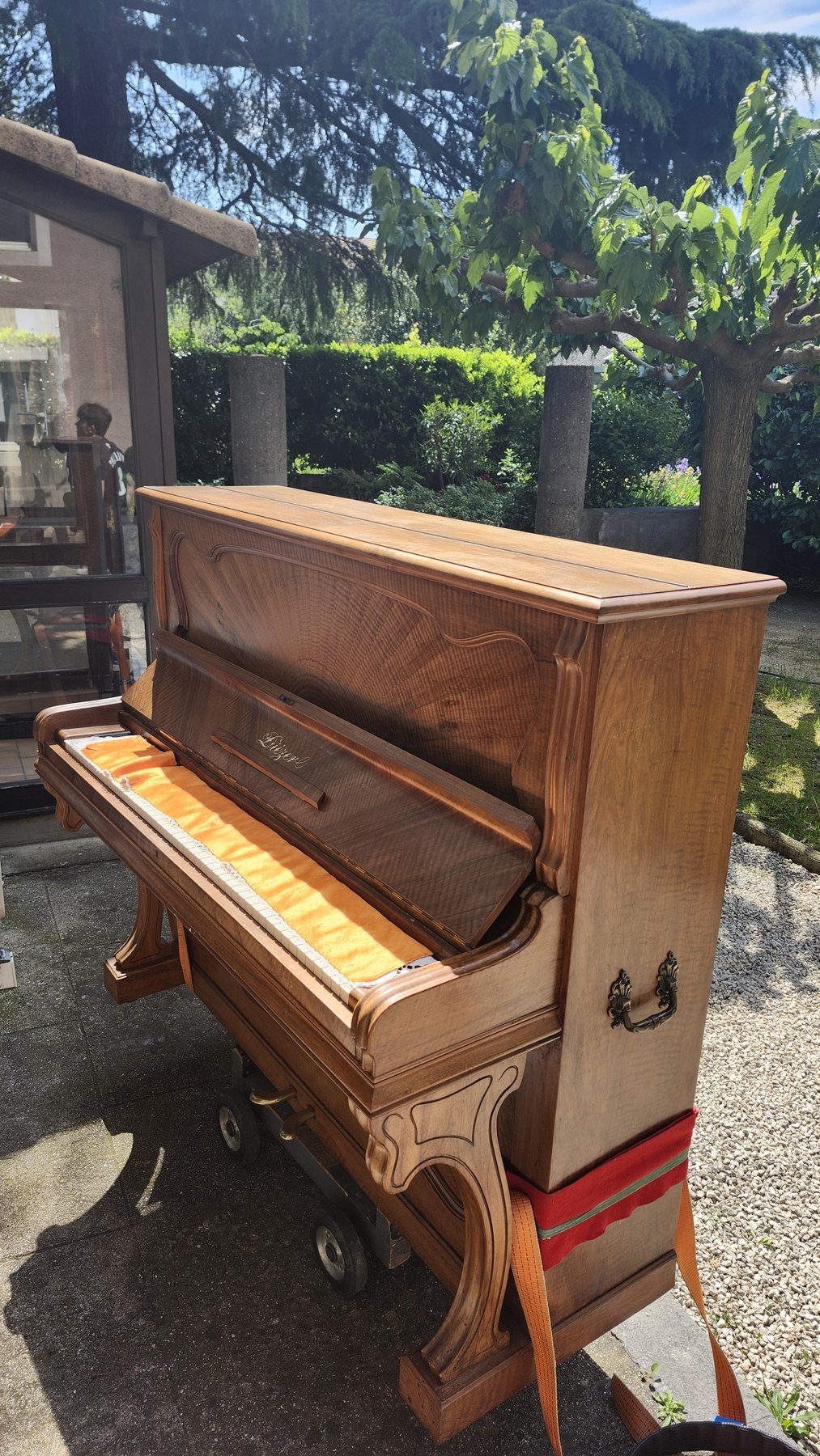 Piano droit sanglé sur un chariot de transport